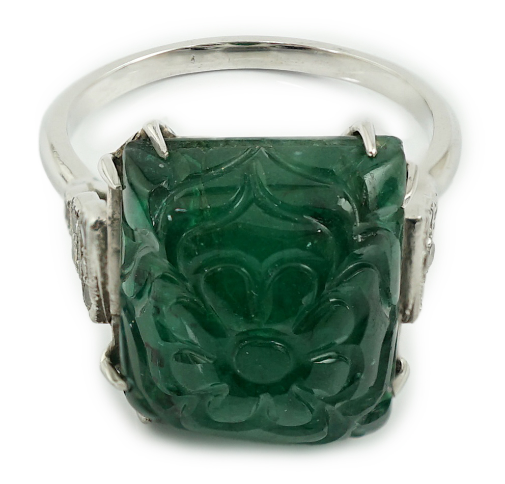 A French 1920's style platinum and single stone emerald set dress ring, with twelve stone millegrain set diamond stepped shoulders